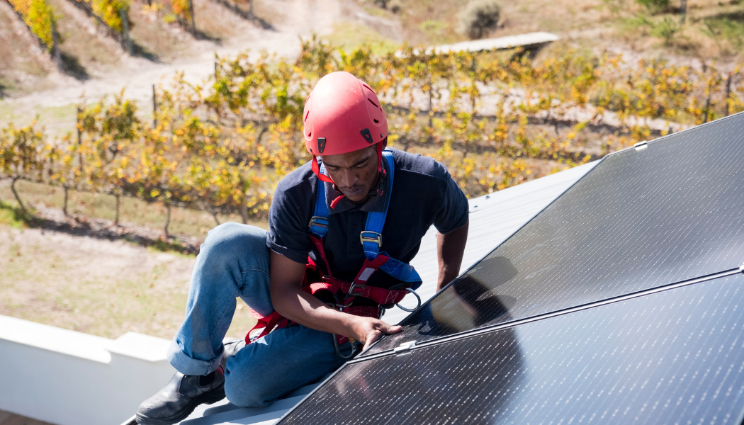 homme équipé pour installer un panneau solaire sur un toit