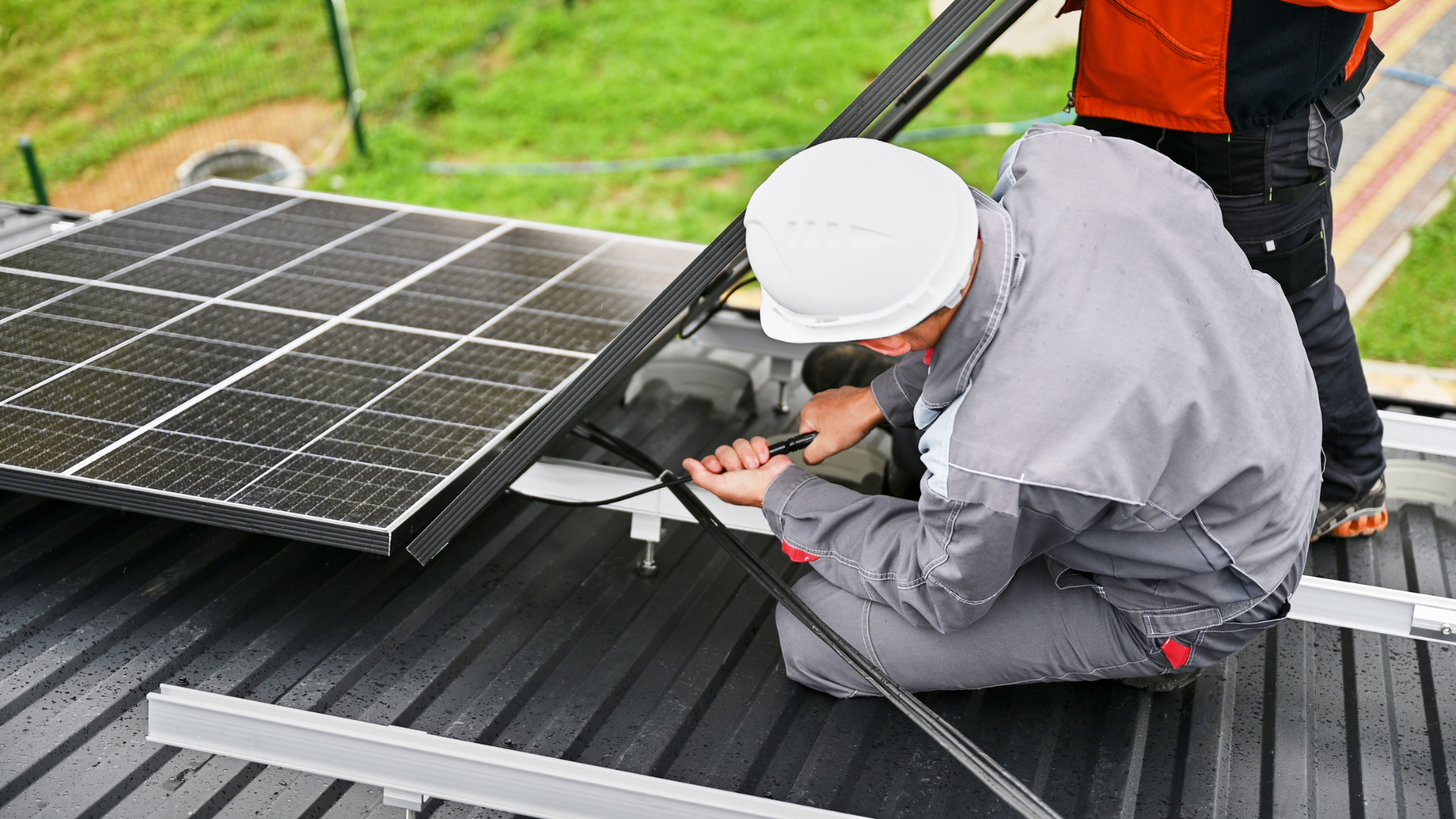 Des techniciens en train de procéder à la maintenance de panneaux solaires sur le toit d'une maison